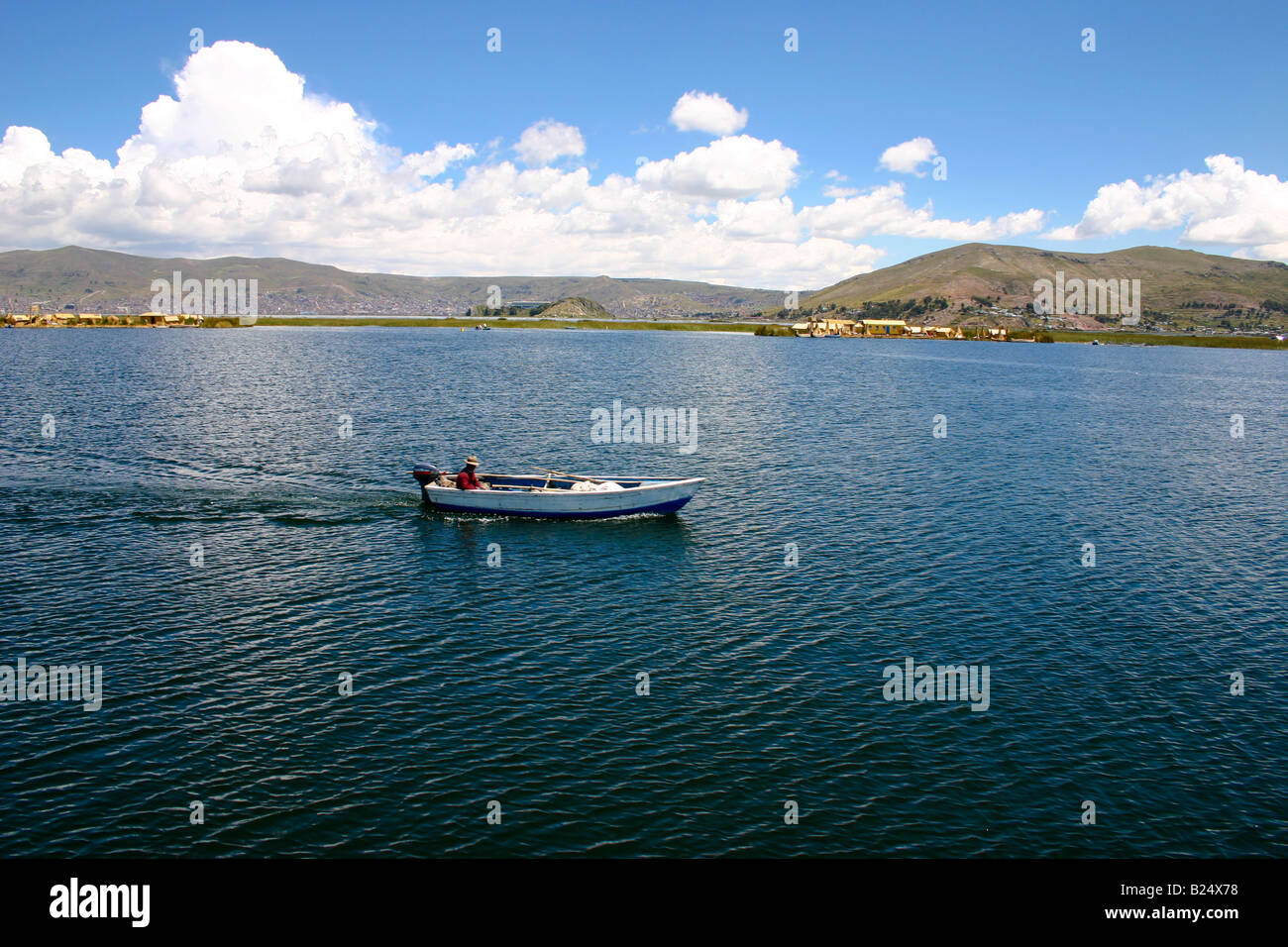Man driving a small motor boat at Lake Titicaca Puno Peru Stock Photo
