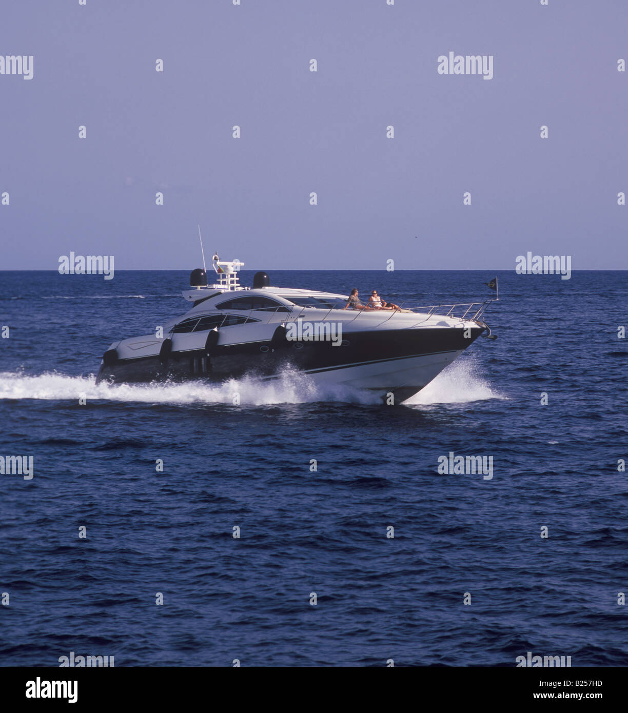 Luxury motor yacht with sunbathing passengers returning at speed to