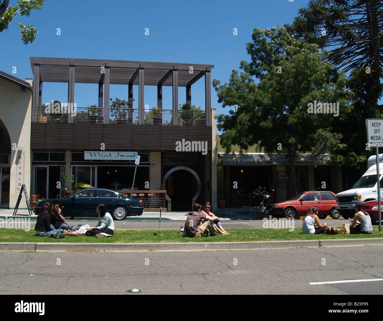 People eating lunch on the median of Shattuck Avenue in Berkeley California in the area known as the Gourmet Ghetto Stock Photo