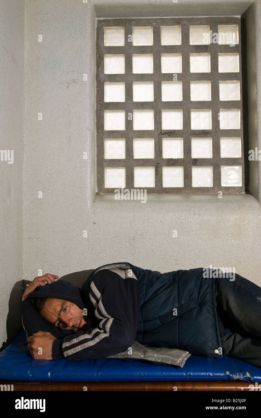 White male offender locked up overnight in a police cell Stock Photo