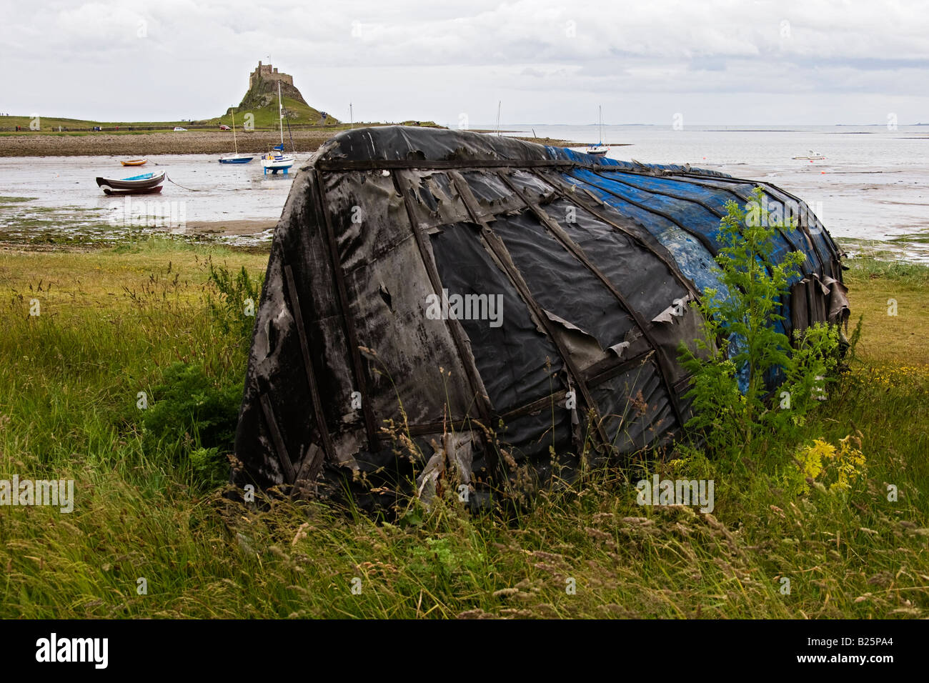 Wrecked wooden boat at shore of Holy Island in England. Stock Photo