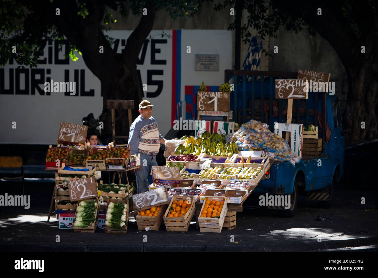 Fruit vendor unloading fresh fruit from truck at market Catania, Sicily, Italy Stock Photo