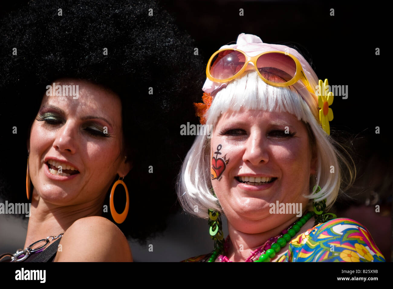 Two women wearing wigs and sunglasses during a german country music party the Schlagermove in Hamburg, Germany Stock Photo