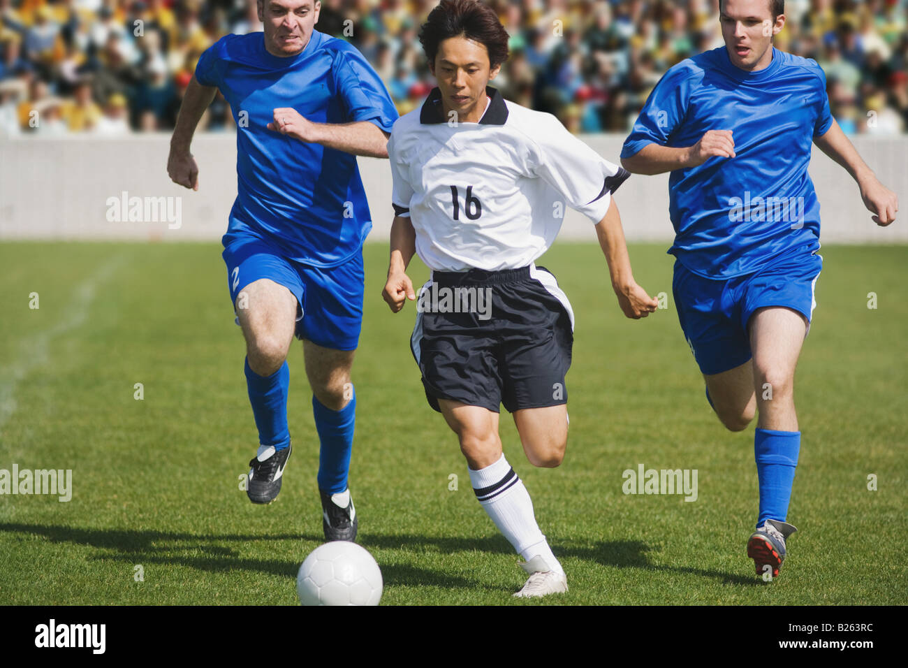 Soccer Player Dribbling Past Defenders Stock Photo