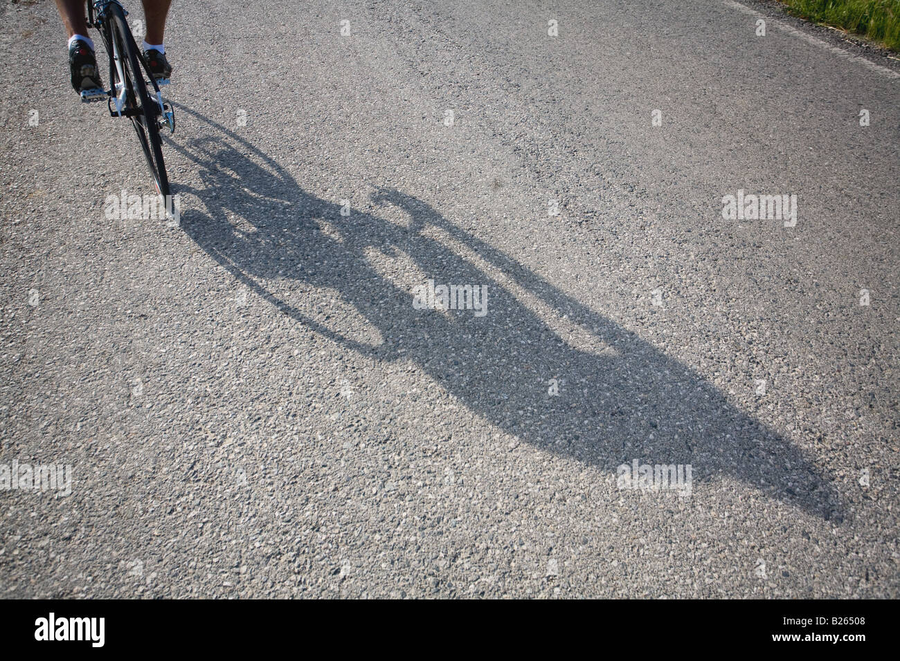 Shadow of a bicyclist casting on road Stock Photo