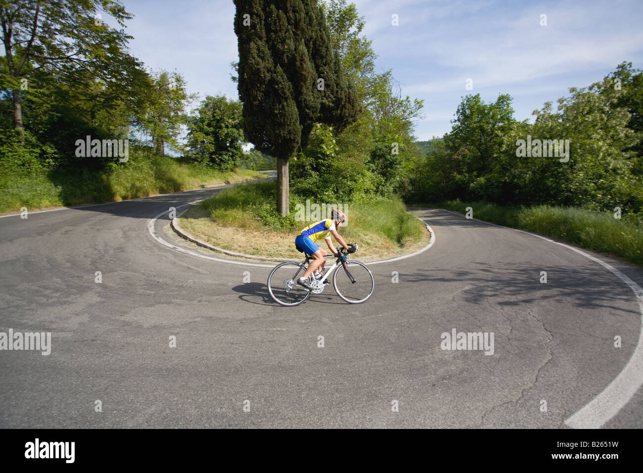 Cyclist cornering on switchback road,  side view Stock Photo