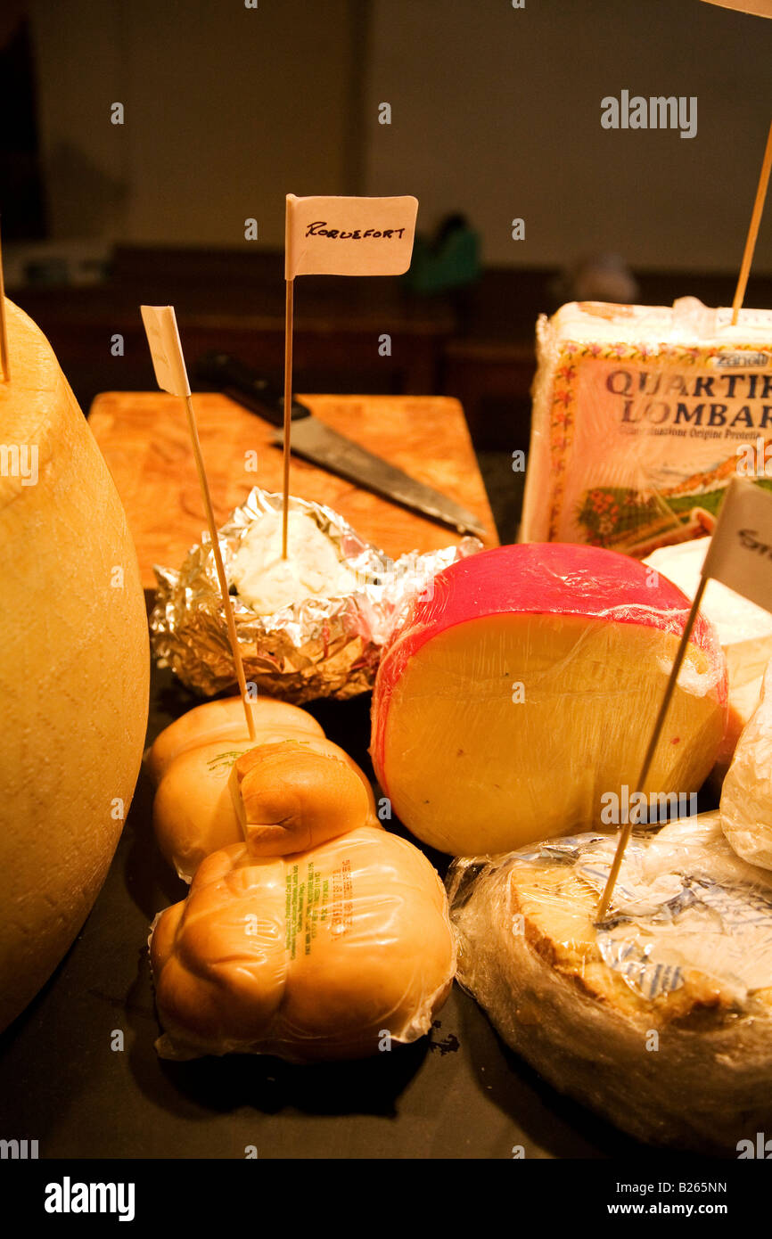 Cheeses are offered for sale in a delicatessen. This shop is based in