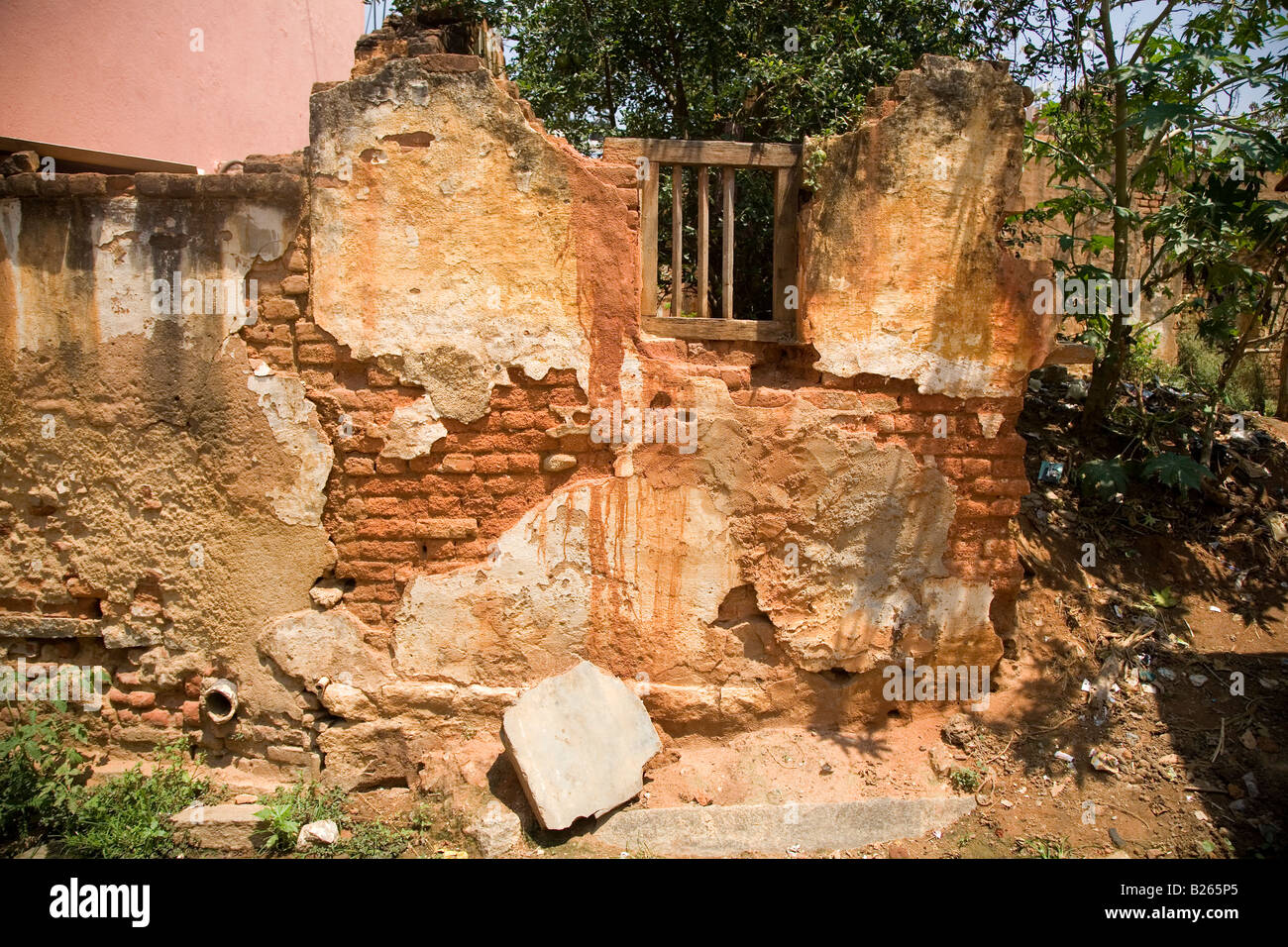 The wall of a delapidated house in Bangalore, India. The plaster has crumbled and bricks are exposed. Stock Photo