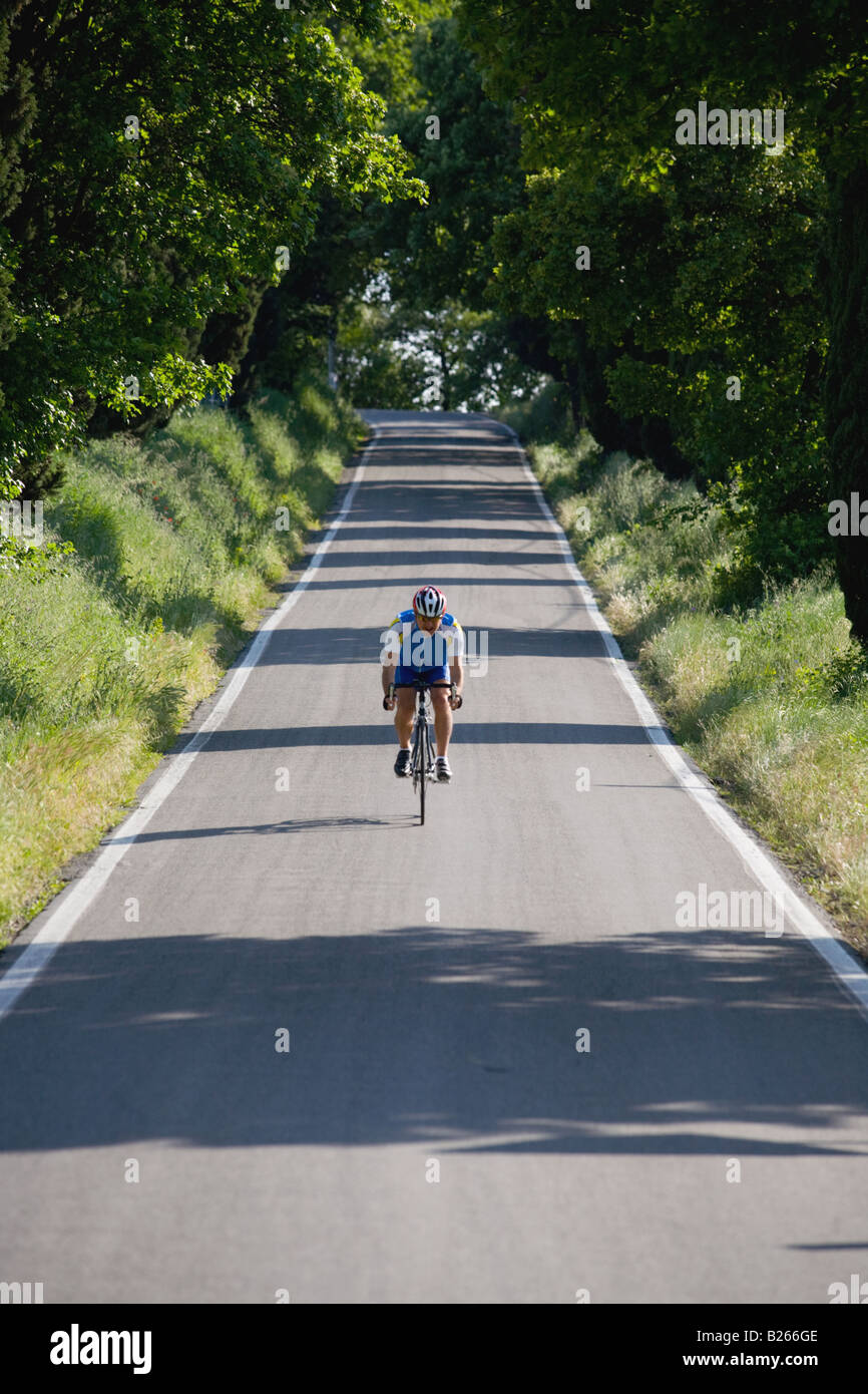 Cyclist riding bicycle on deserted road, front view Stock Photo