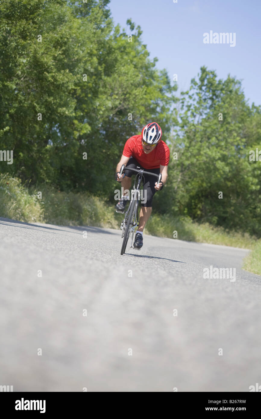 Front view of a man cycling on road Stock Photo