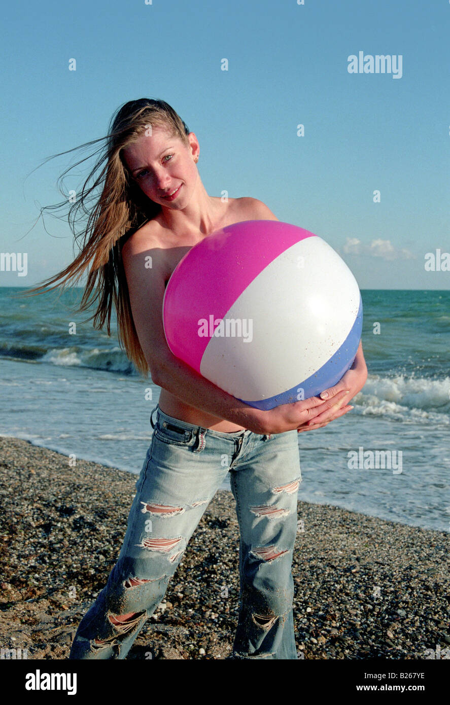 shirtless woman play with ball on a beach Stock Photo