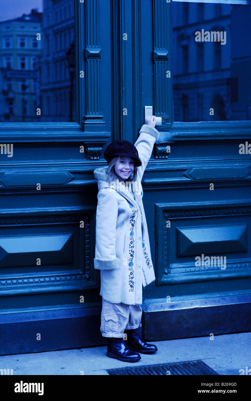 small girl standing in front of a door Stock Photo - Alamy
