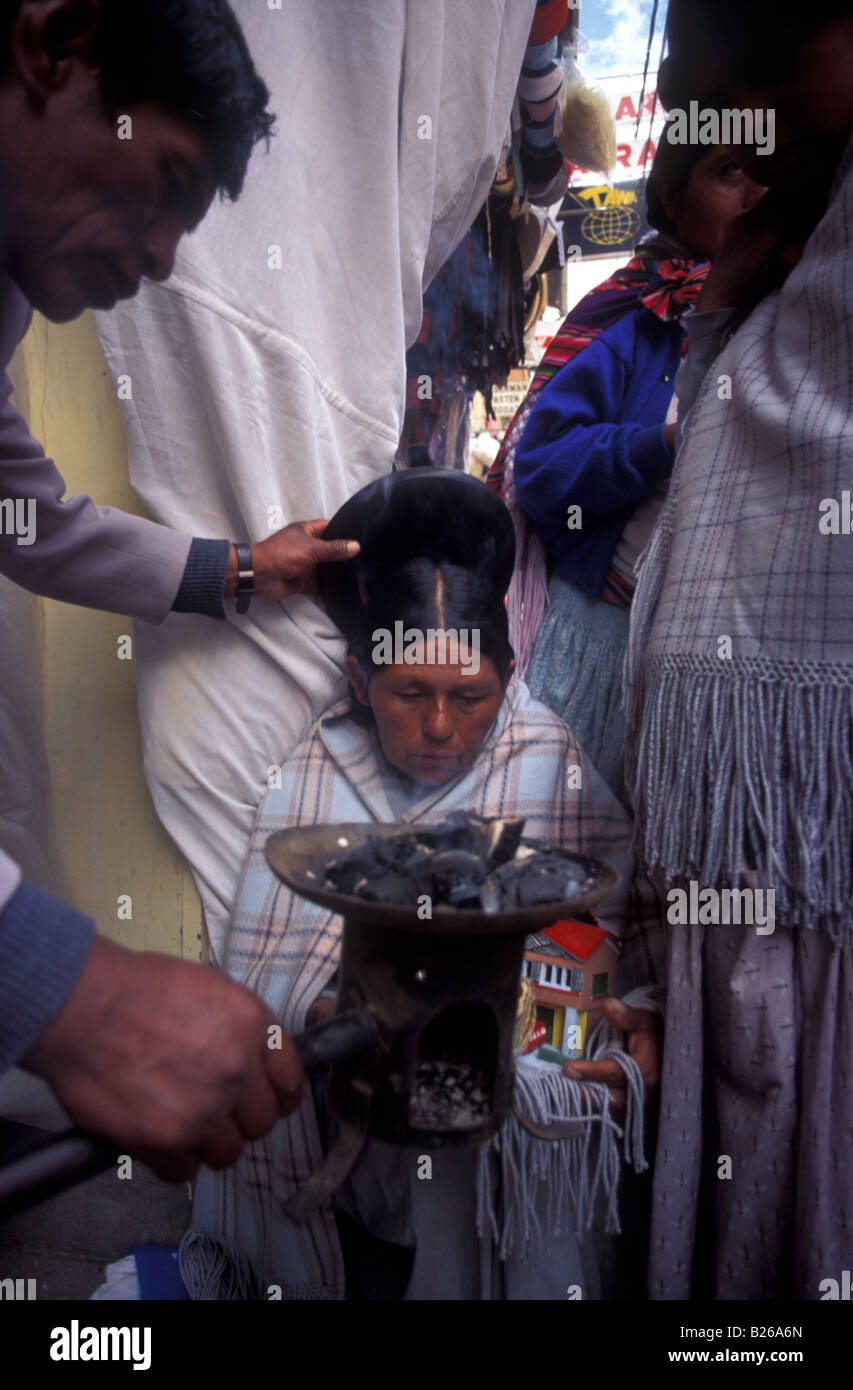 An indigenous woman has a dummy of her home ritually blessed for good fortune Witch doctor s market La Paz Stock Photo