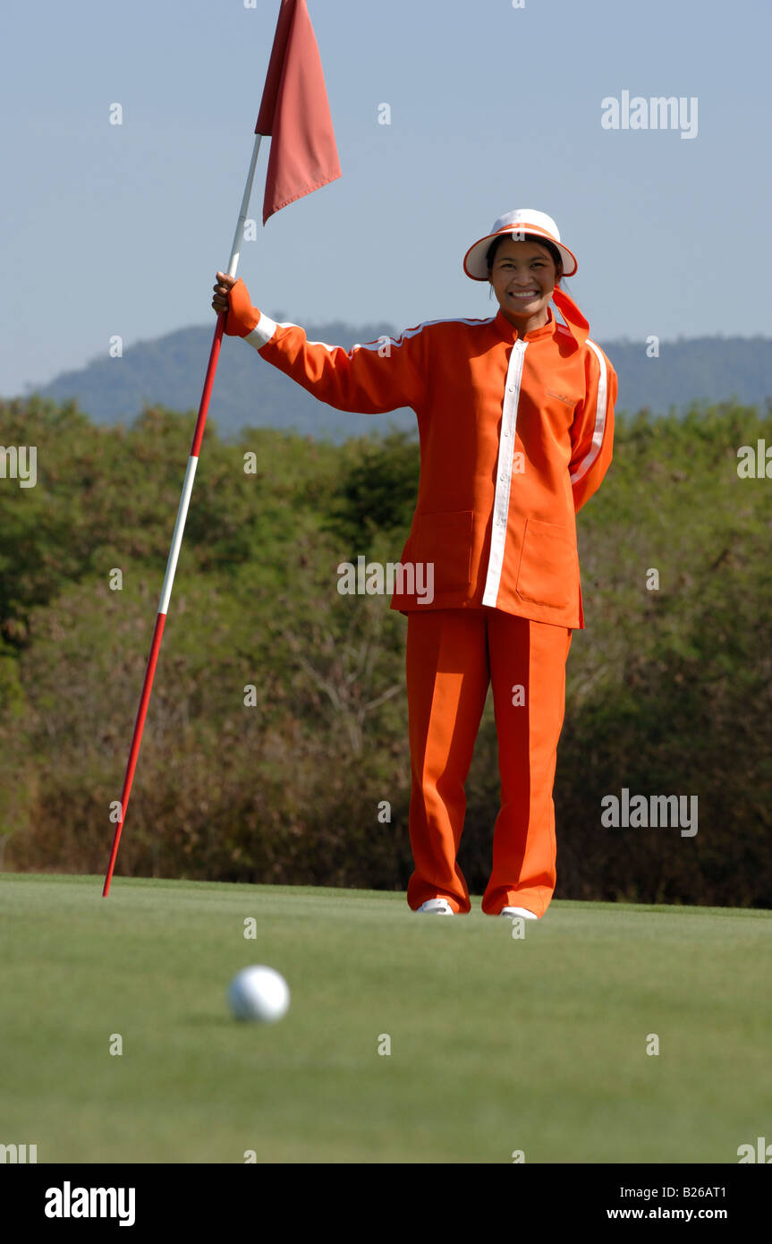 Woman, female caddy holding the flag, Kirimaya Golf Course, Khao Yai National Park, Thailand