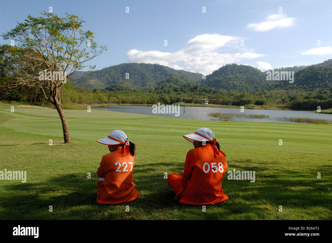Two women sitting on the grass, caddy, Kirimaya Golf Course, Khao Yai