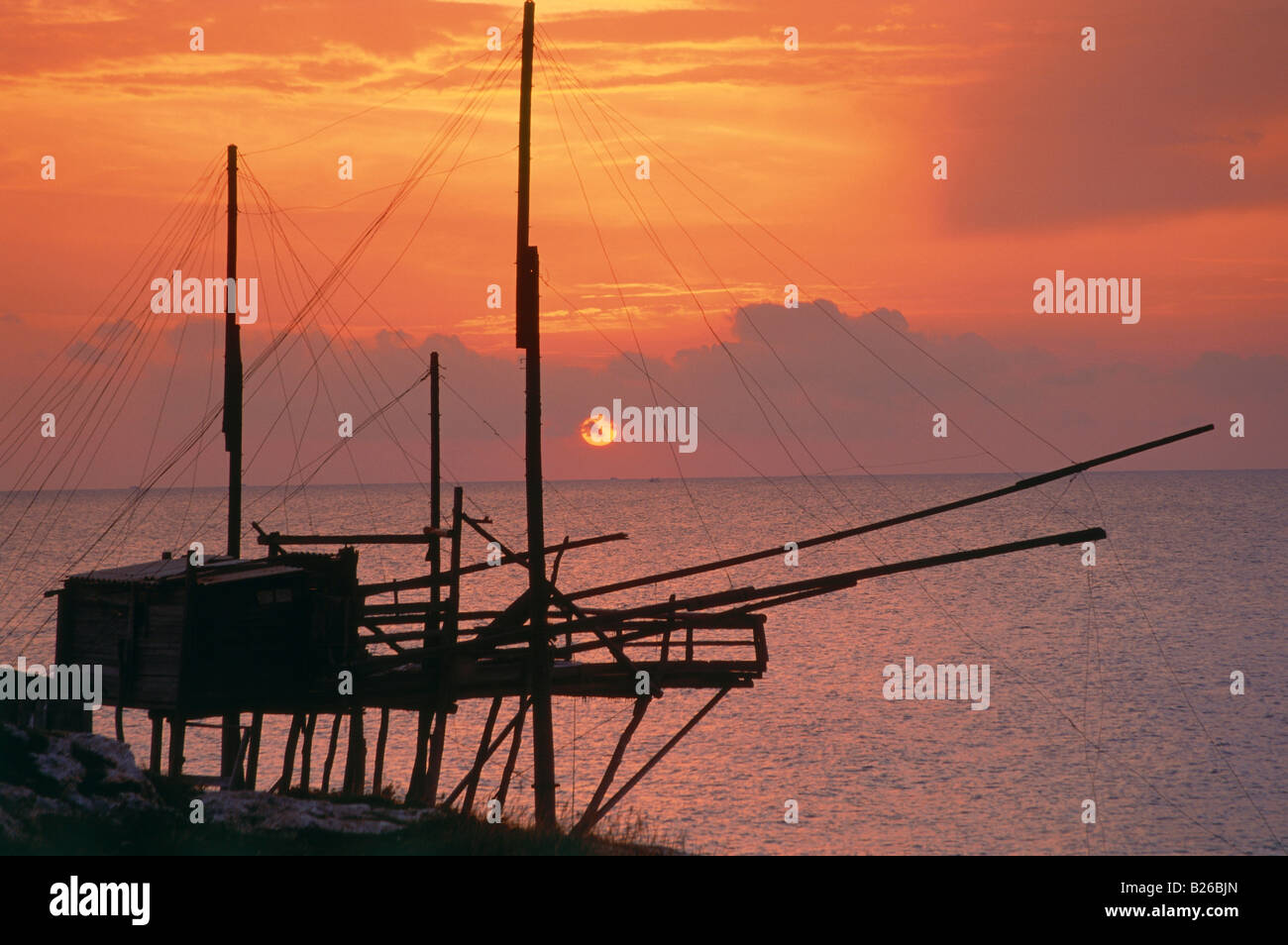 Silouette of a fishing net frame at sunrise, Trabucco, Punta Lunga near Vieste, Gargano, Apulia, Italy Stock Photo