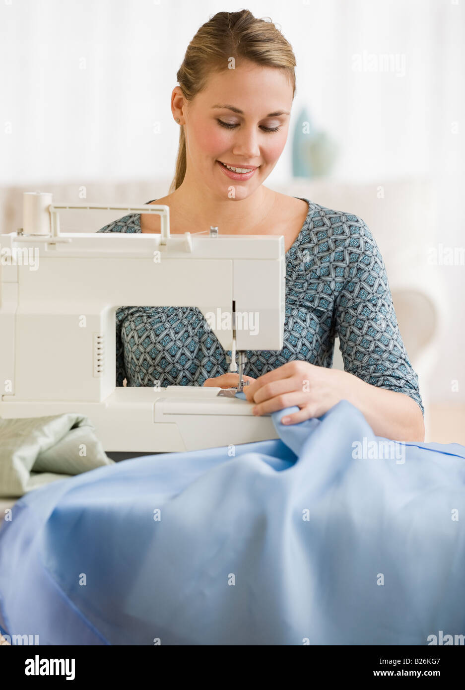 Woman using sewing machine Stock Photo Alamy