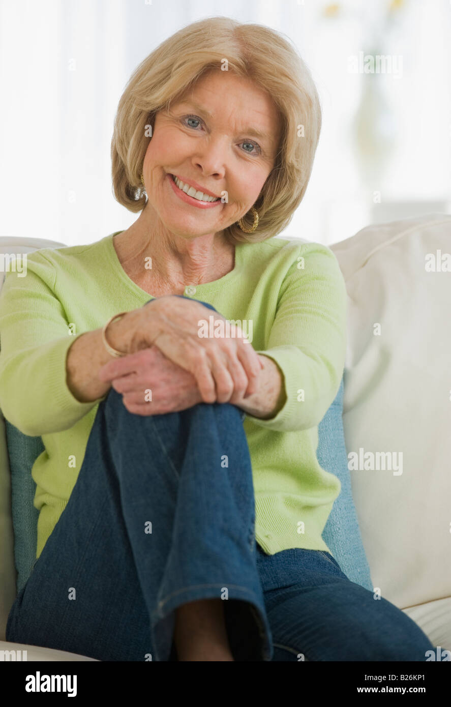Senior woman sitting on sofa Stock Photo - Alamy