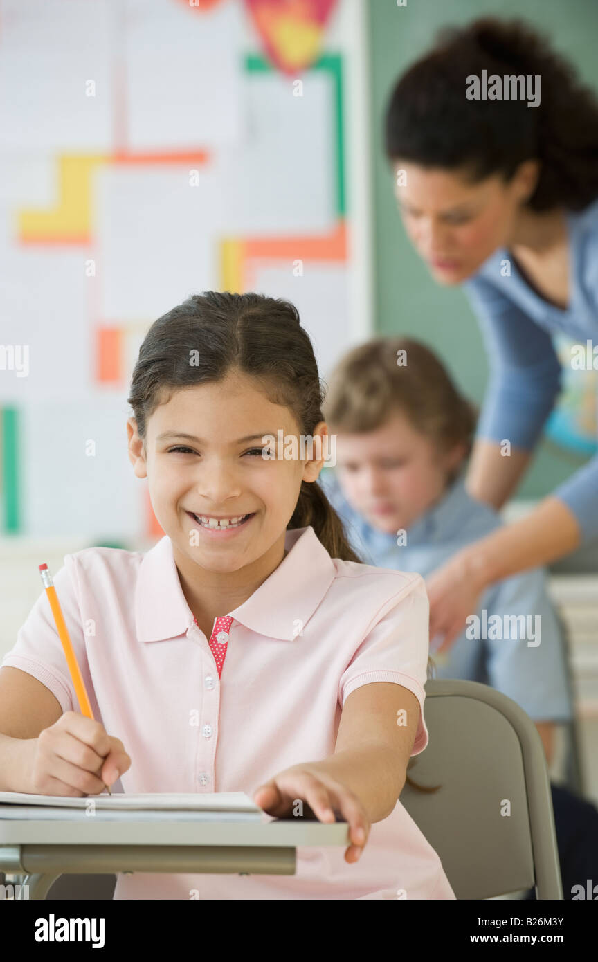 Hispanic girl writing at school desk Stock Photo Alamy