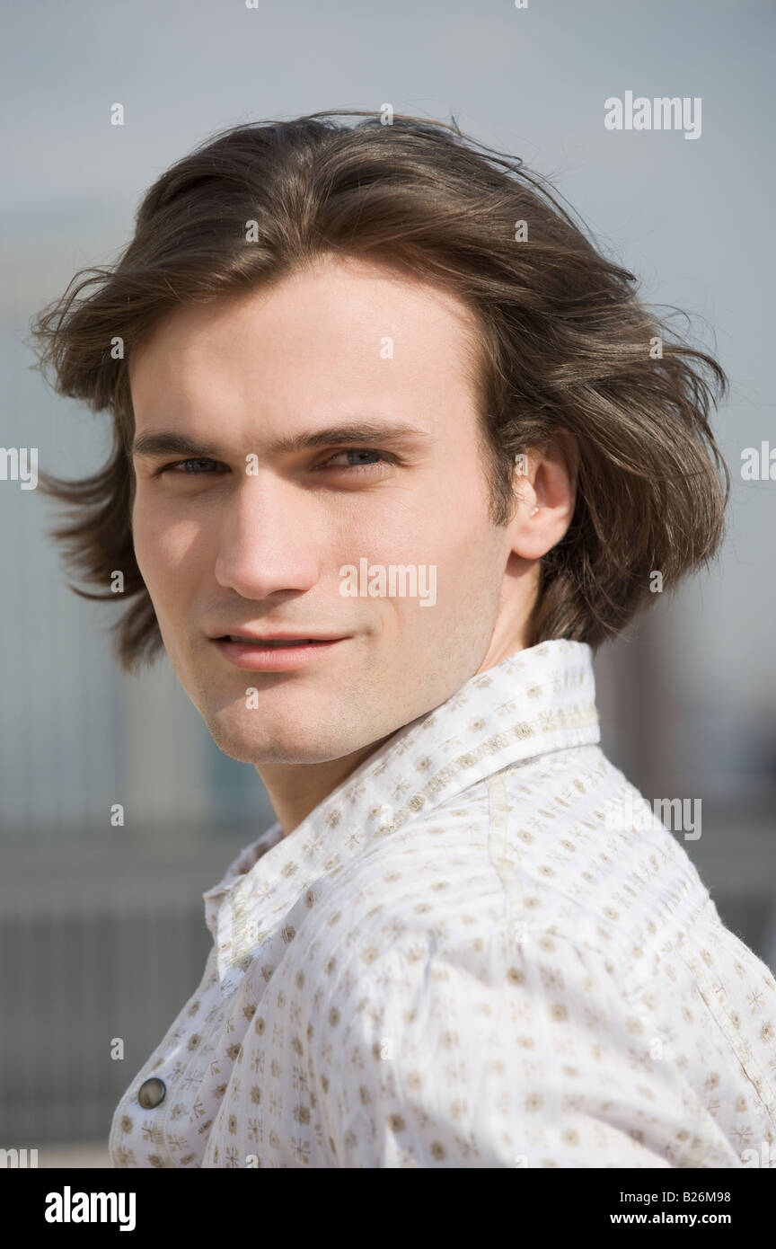 Man with hair blowing looking over shoulder Stock Photo