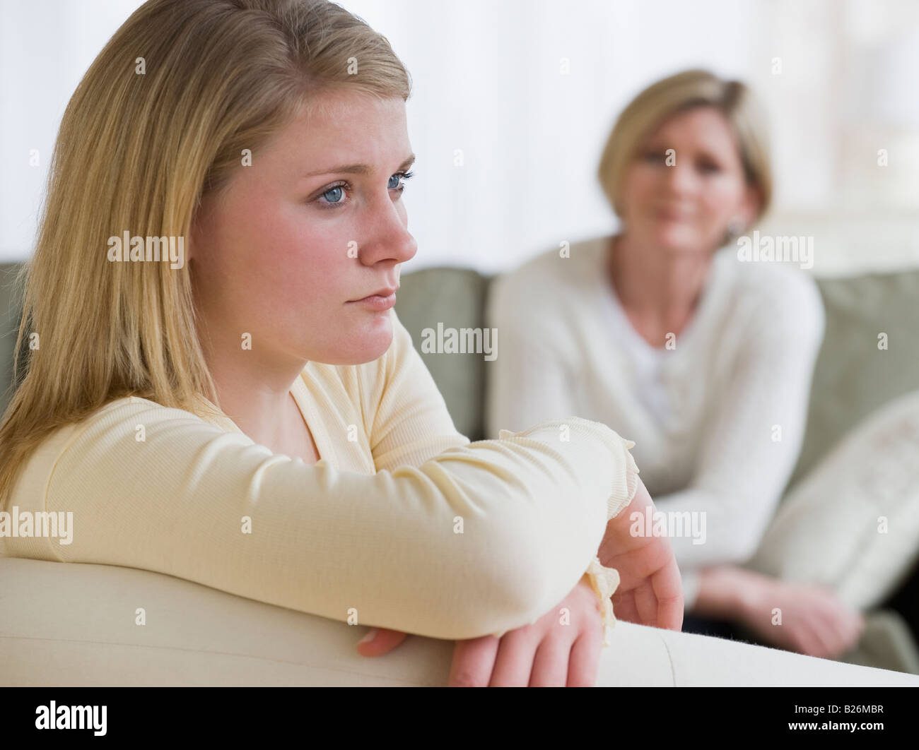 Teenaged girl looking away from mother Stock Photo
