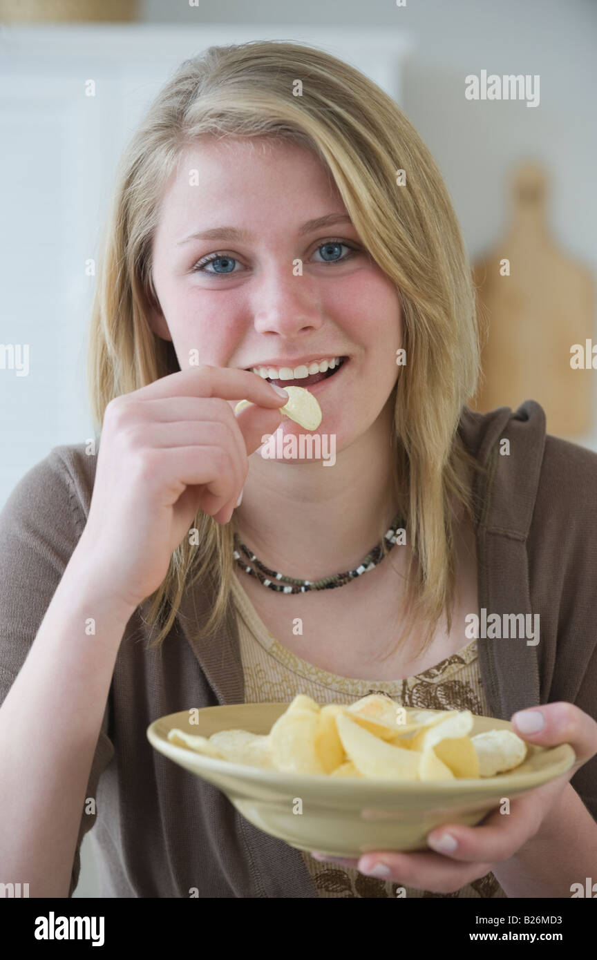 Teenaged girl eating potato chips Stock Photo