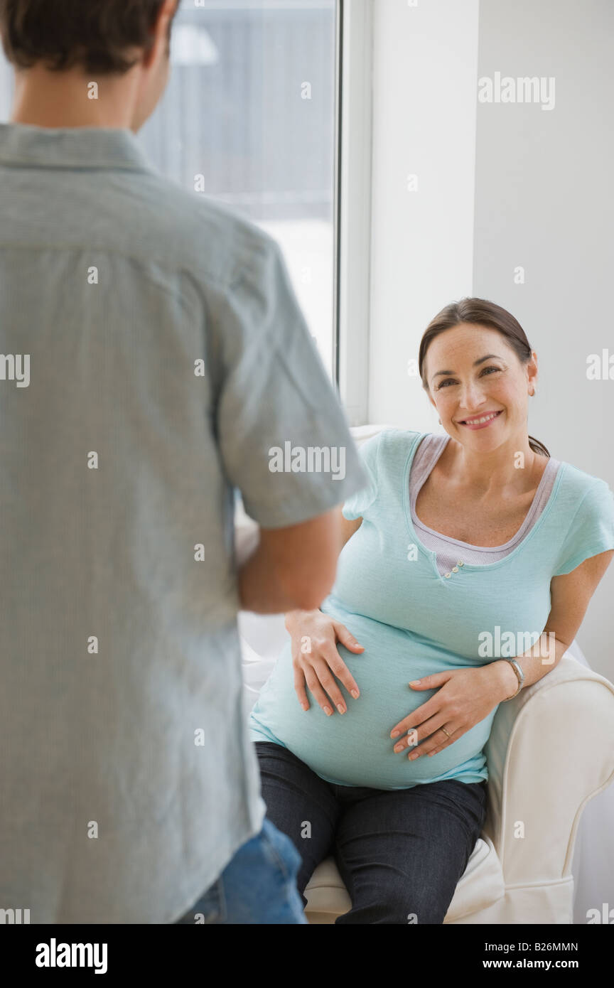 Pregnant Hispanic woman smiling at husband Stock Photo