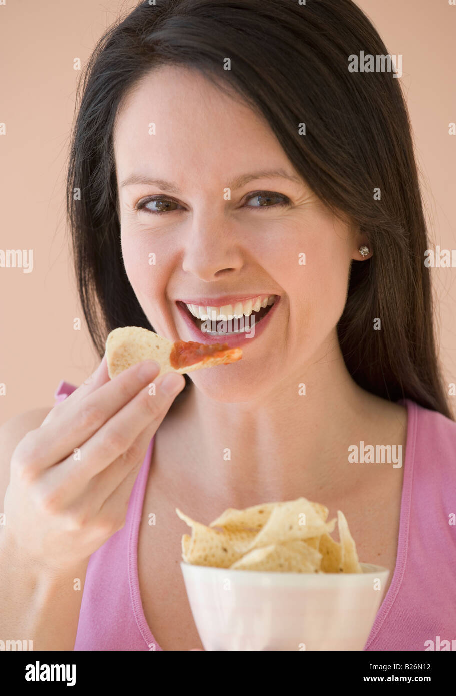 Woman eating chips and dip Stock Photo Alamy