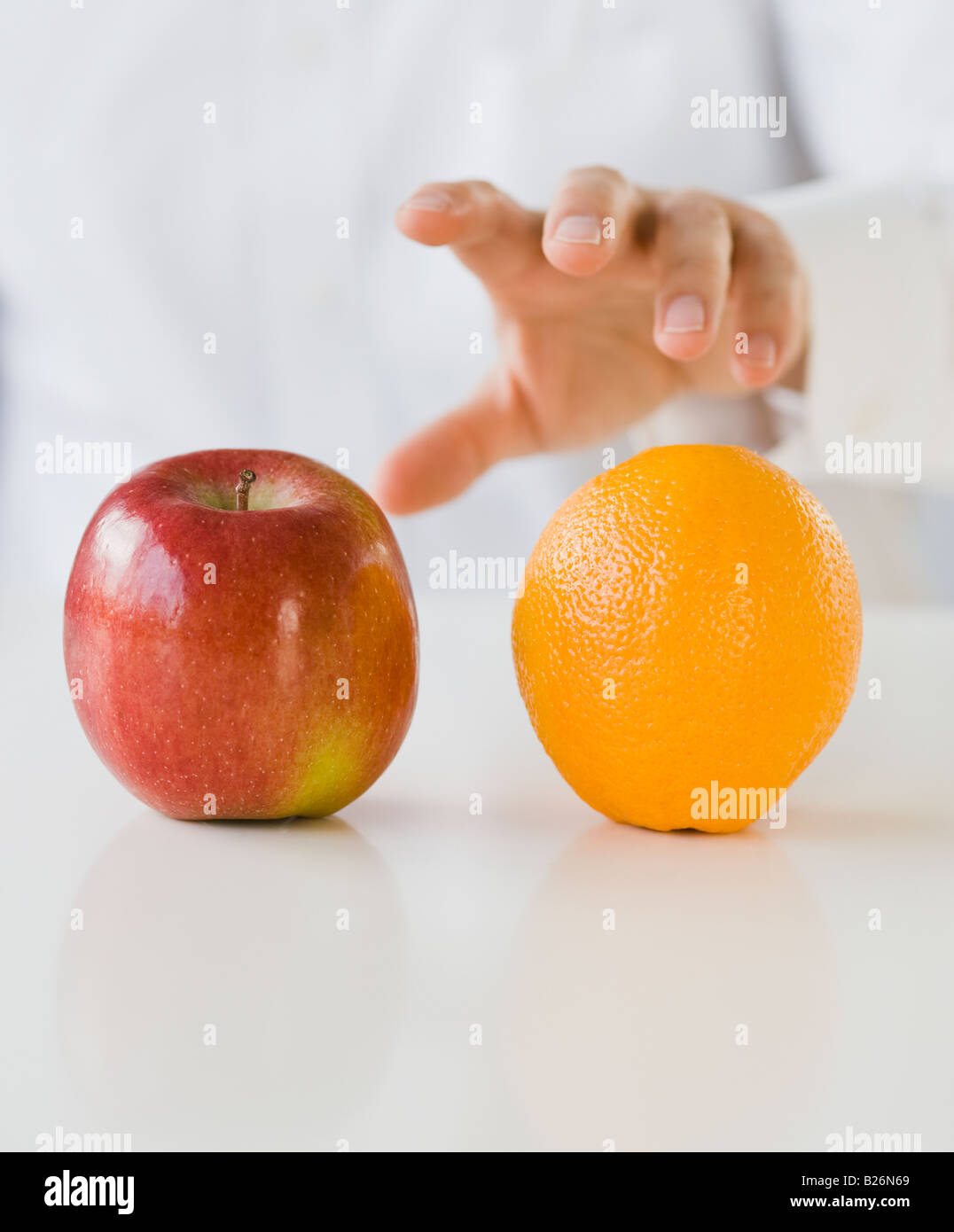 Man reaching for apple and orange Stock Photo