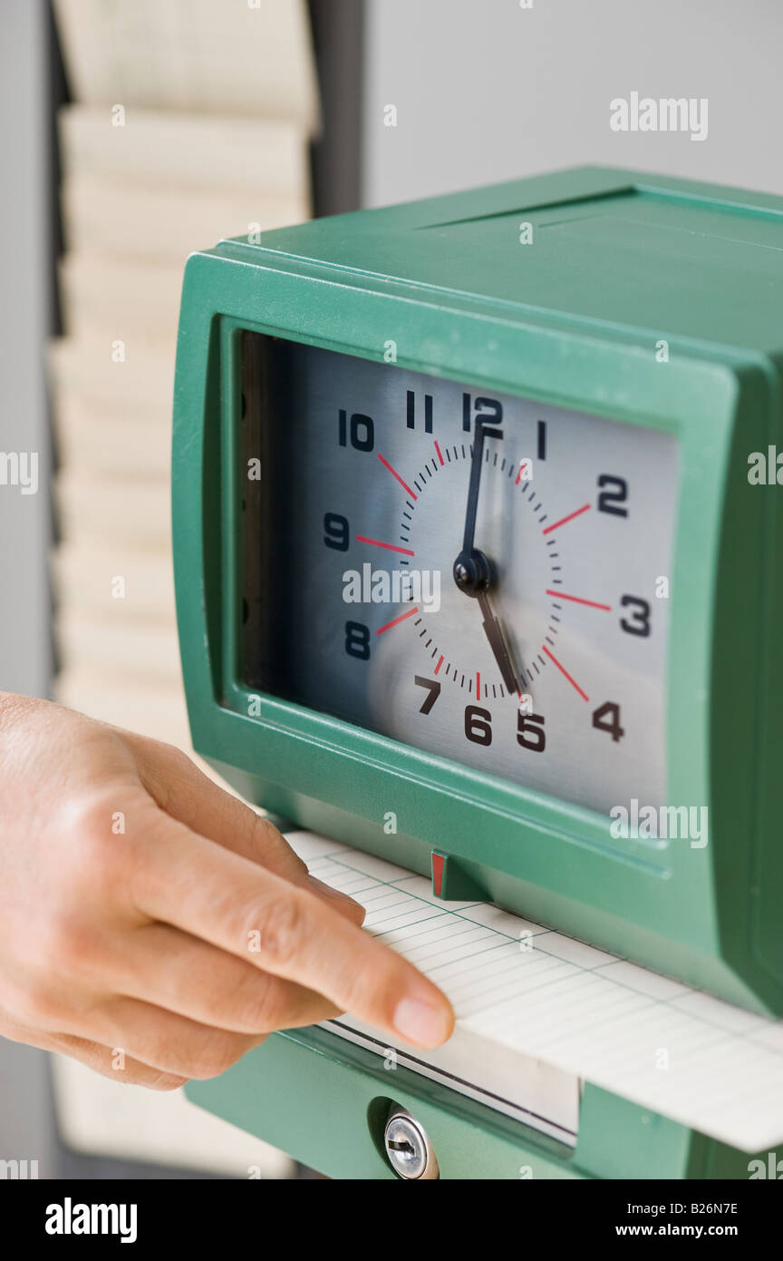 Man punching card in time clock Stock Photo Alamy