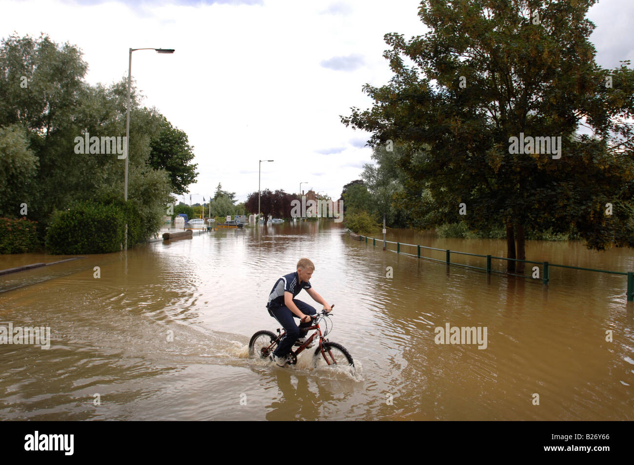 A BOY CYCLES THROUGH FLOODWATER IN TEWKESBURY DURING THE FLOODS IN