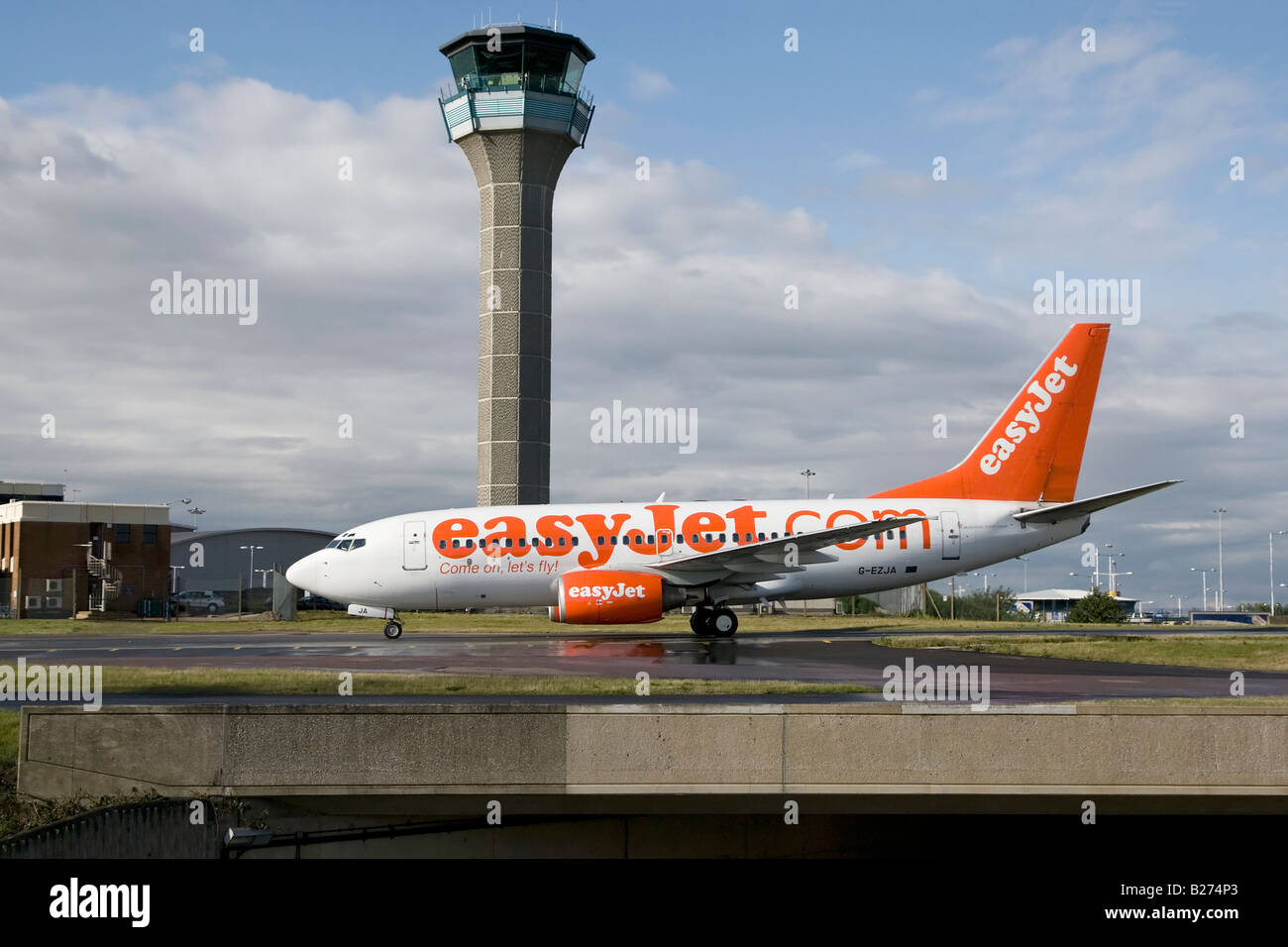 A Boeing B737 series 700 of the UK s budget airline EasyJet taxy s past the ATC tower at Luton Airport Stock Photo