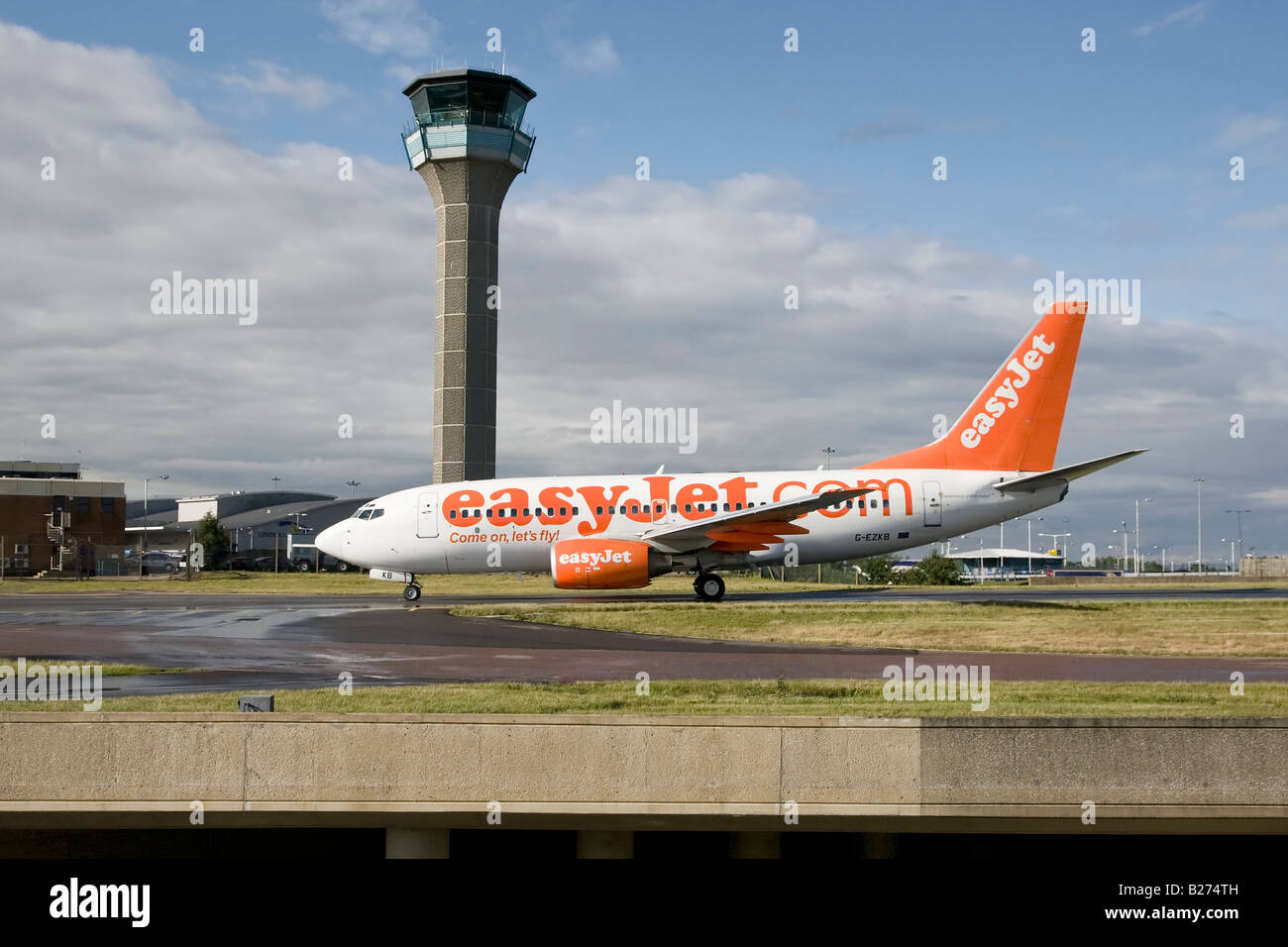 A Boeing B737 series 700 of the UK s budget airline EasyJet taxy s past the ATC tower at Luton Airport Stock Photo