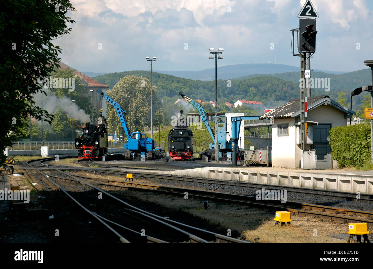 Loading coal onto steam locomotives at Wernigerode with Mount Brocken summit in background, Harz, Germany. Stock Photo