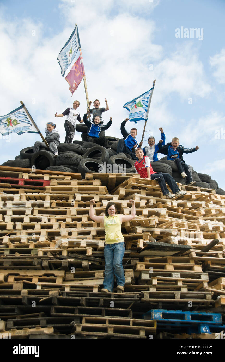 children cheer while on top of a bonfire, Monkstown, Newtownabbey. Stock Photo