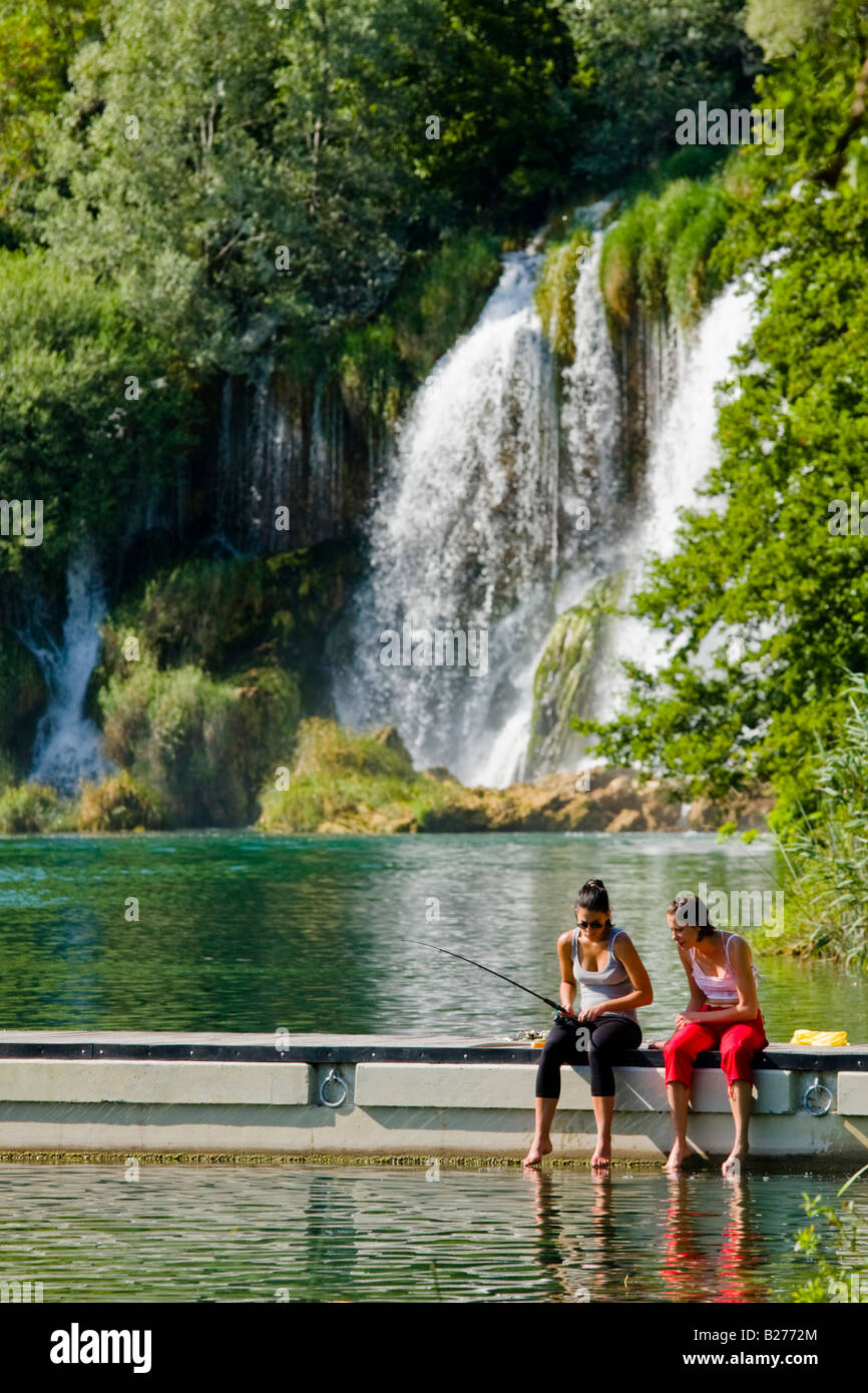 Two girls fishing on pier, Krka waterfalls, Roski slap area, Croatia, Europe Stock Photo