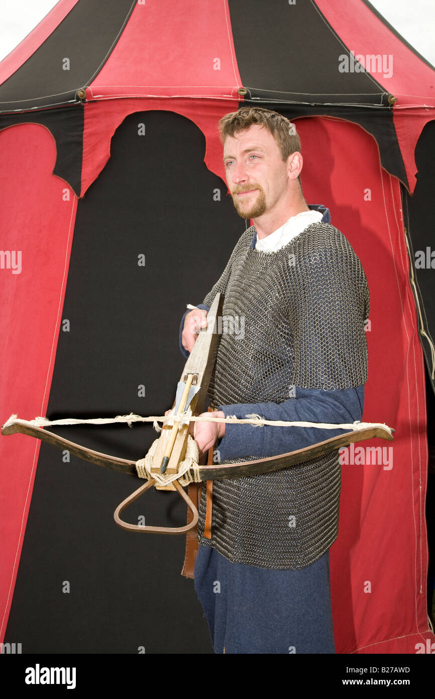 11th-century reenactor outside red tent, holding rampart crossbow at ...