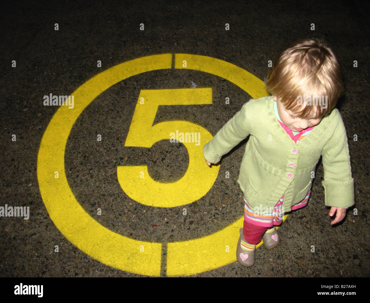Child girl walking on 5 Km/h road sign Stock Photo - Alamy