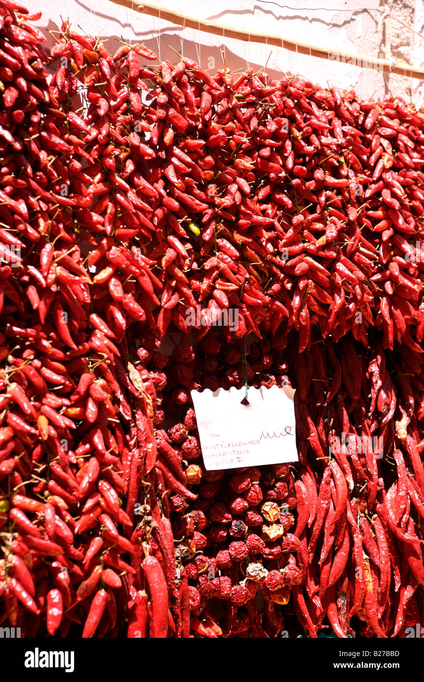 Red chillis hanging for sale outside a vegetable shop in Italy Stock Photo