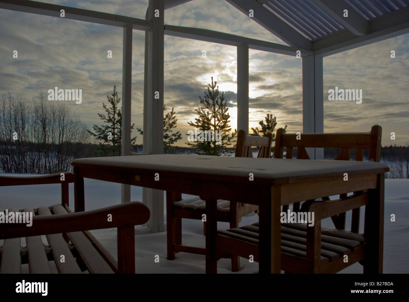 A verandah in Lapland in winter with the furniture covered in snow Stock Photo