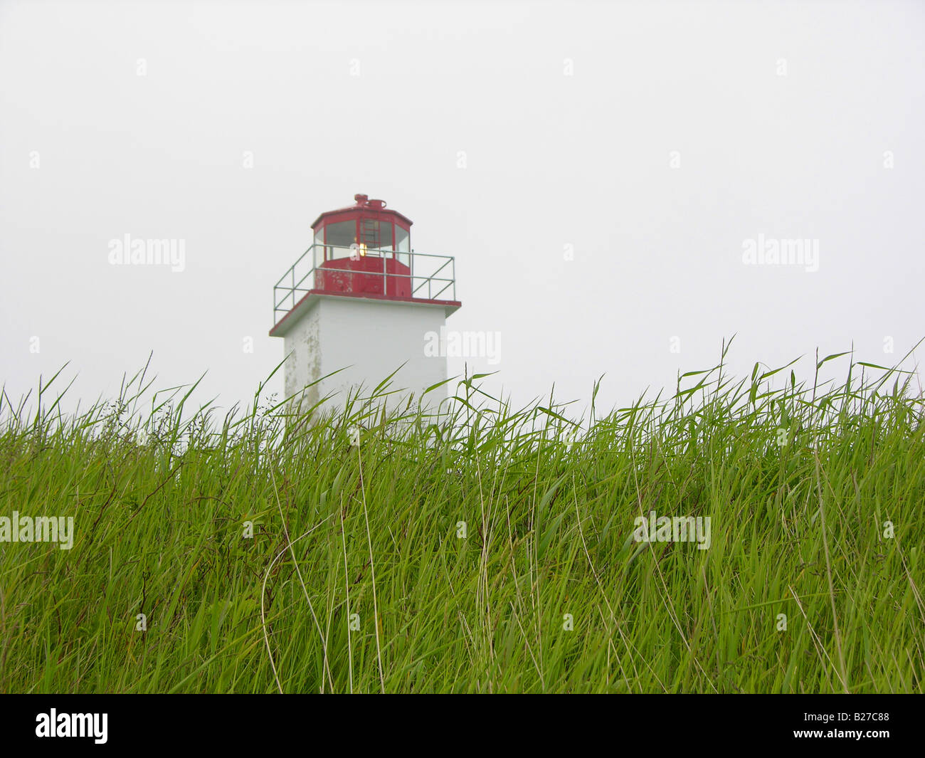Lighthouse on grassy hill. Stock Photo