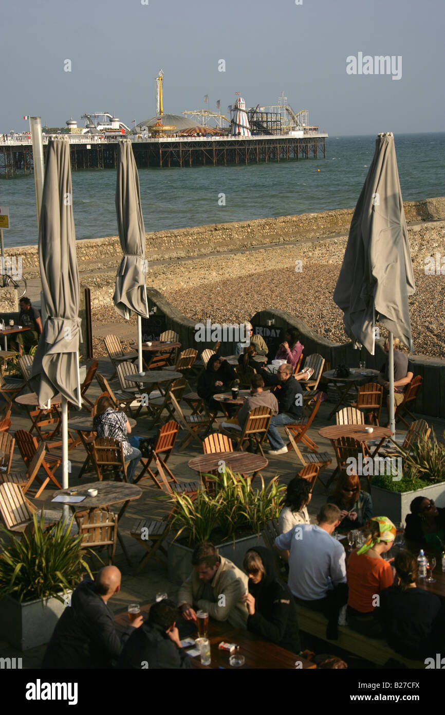 City of Brighton and Hove, England. Visitors in one of the many bars, cafes and restaurants on Brighton beach. Stock Photo