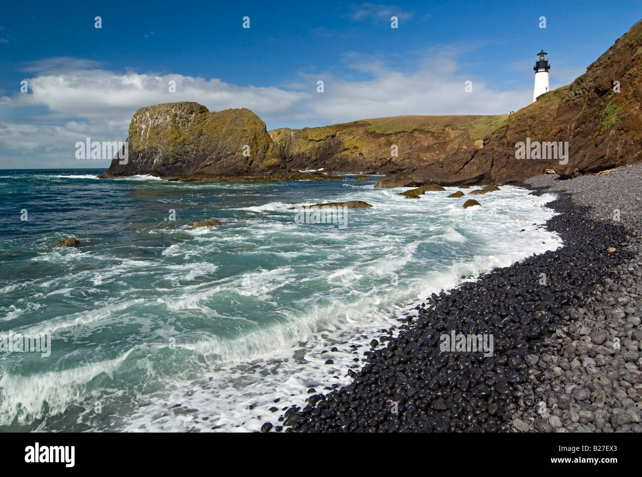 Yaquina Lighthouse on top of rocky beach Stock Photo