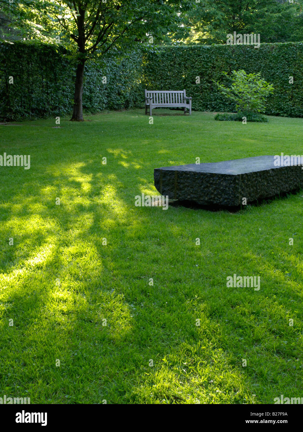 Lawn with stone bench Stock Photo