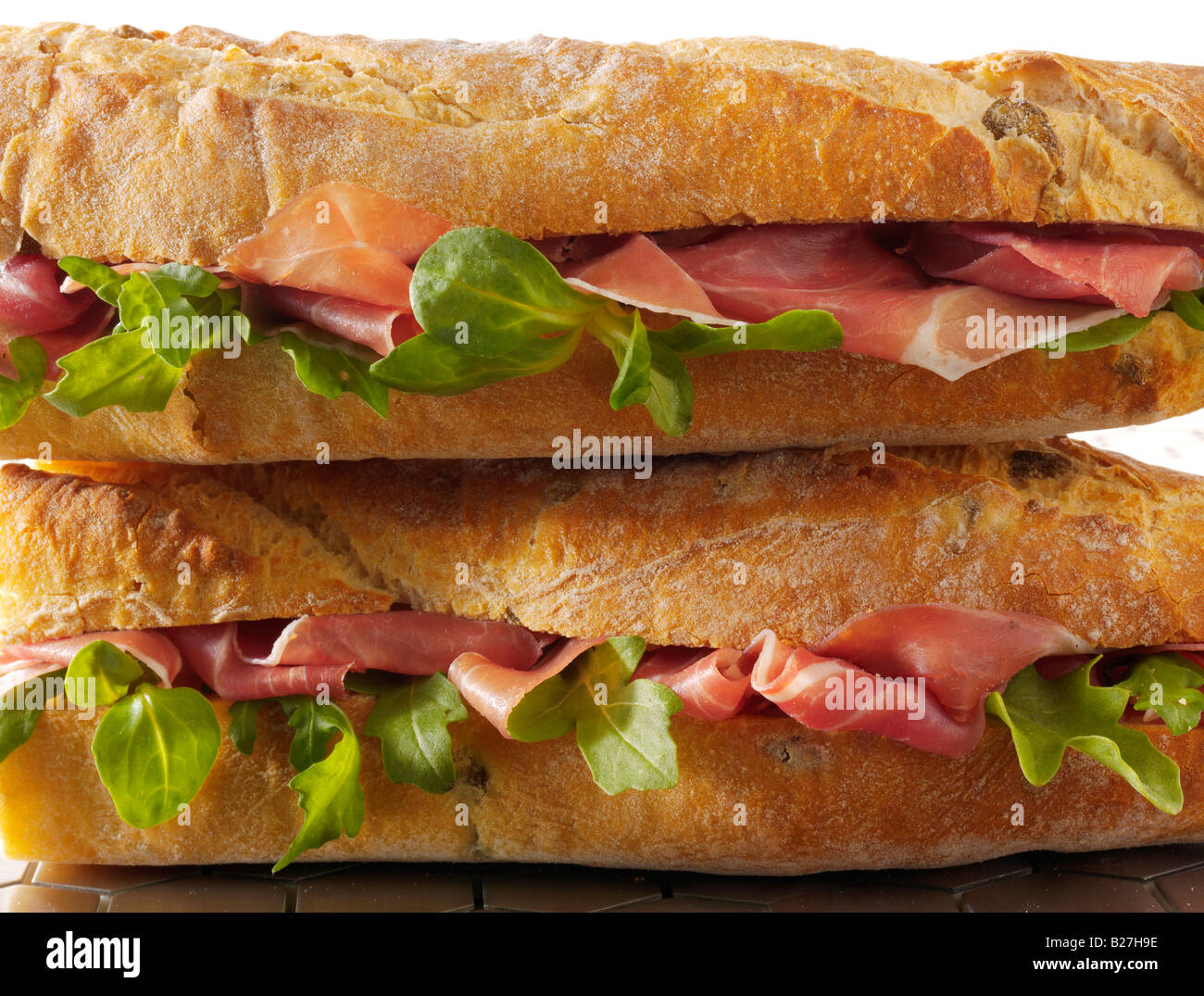 close up of cheese prosciutto and salad baguette in french bread stick Stock Photo