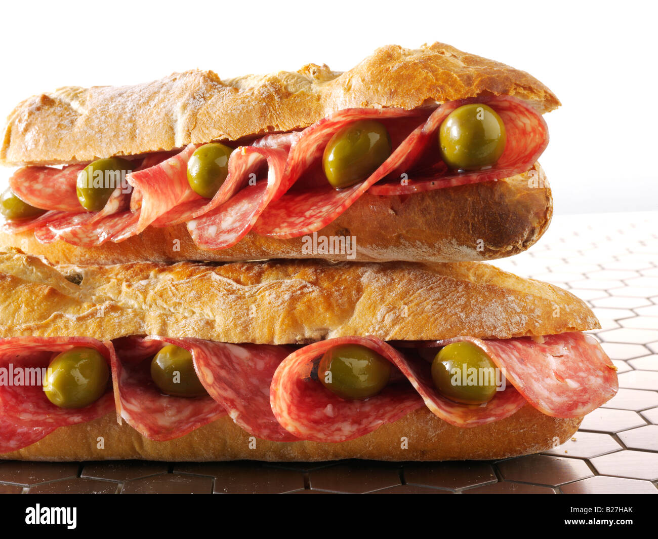 close up of salami and olives baguette in french bread stick Stock