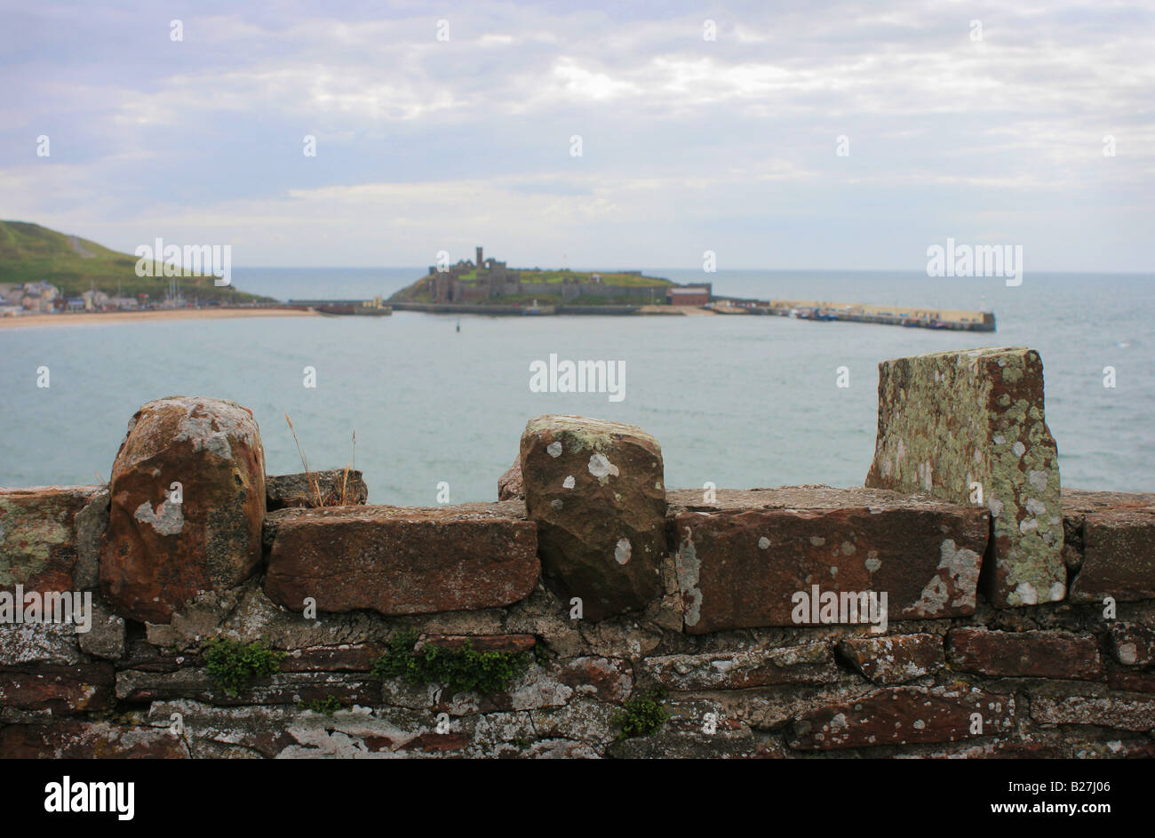 St Patrick Island, Peel, seen from behind an old stone wall, Isle of Man. Stock Photo