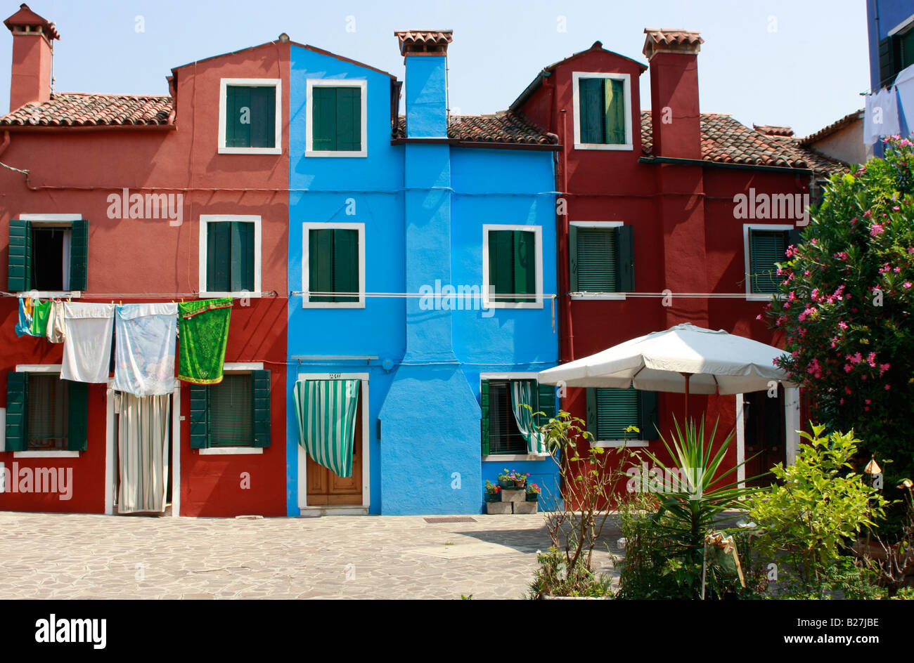 laundry hanging outside the vividly  colorful painted house on the popular Venetian island of Burano Stock Photo