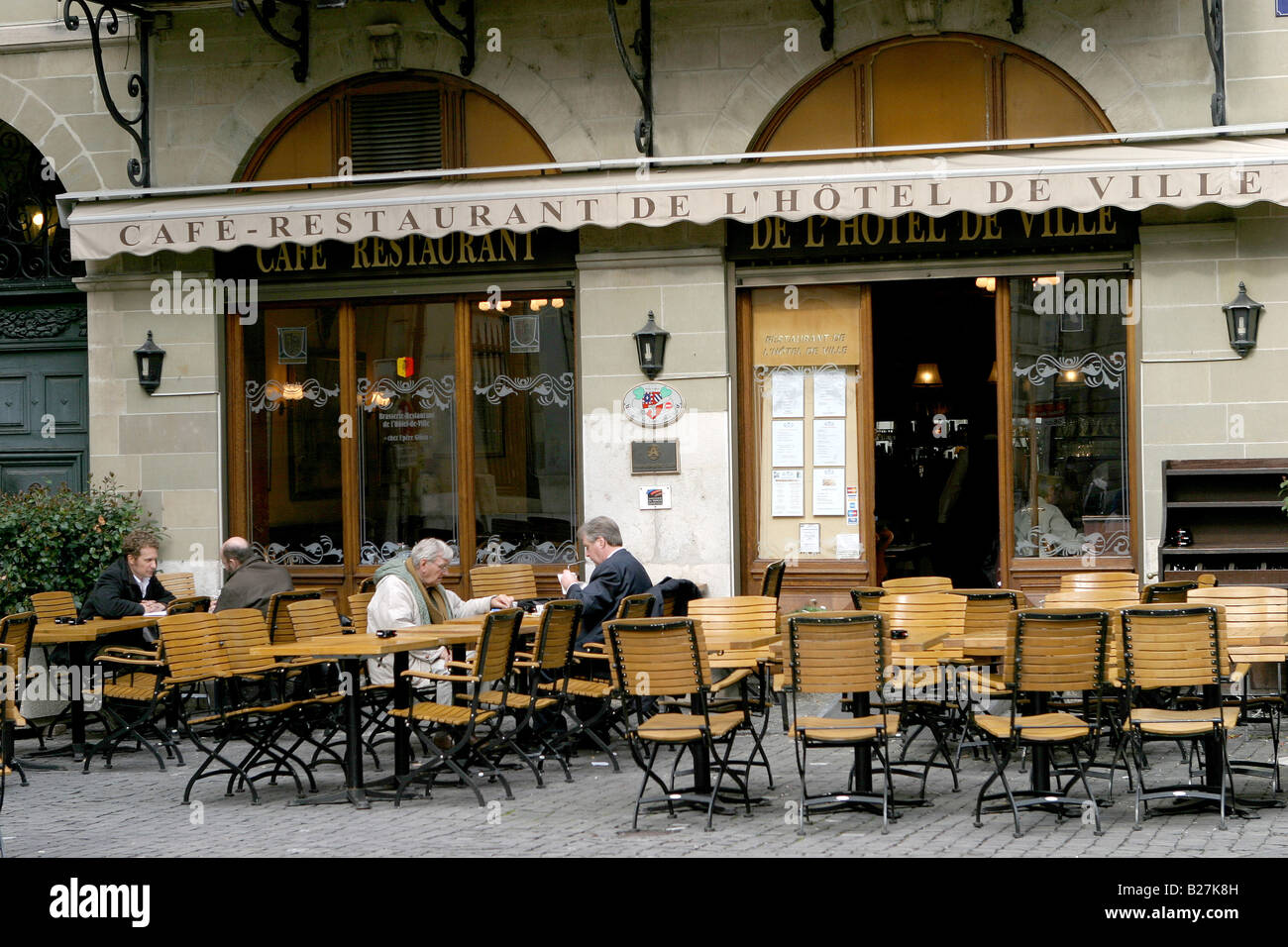 A couple of Genevoise take coffee at an open air cafe in Geneva very early in the spring Stock Photo