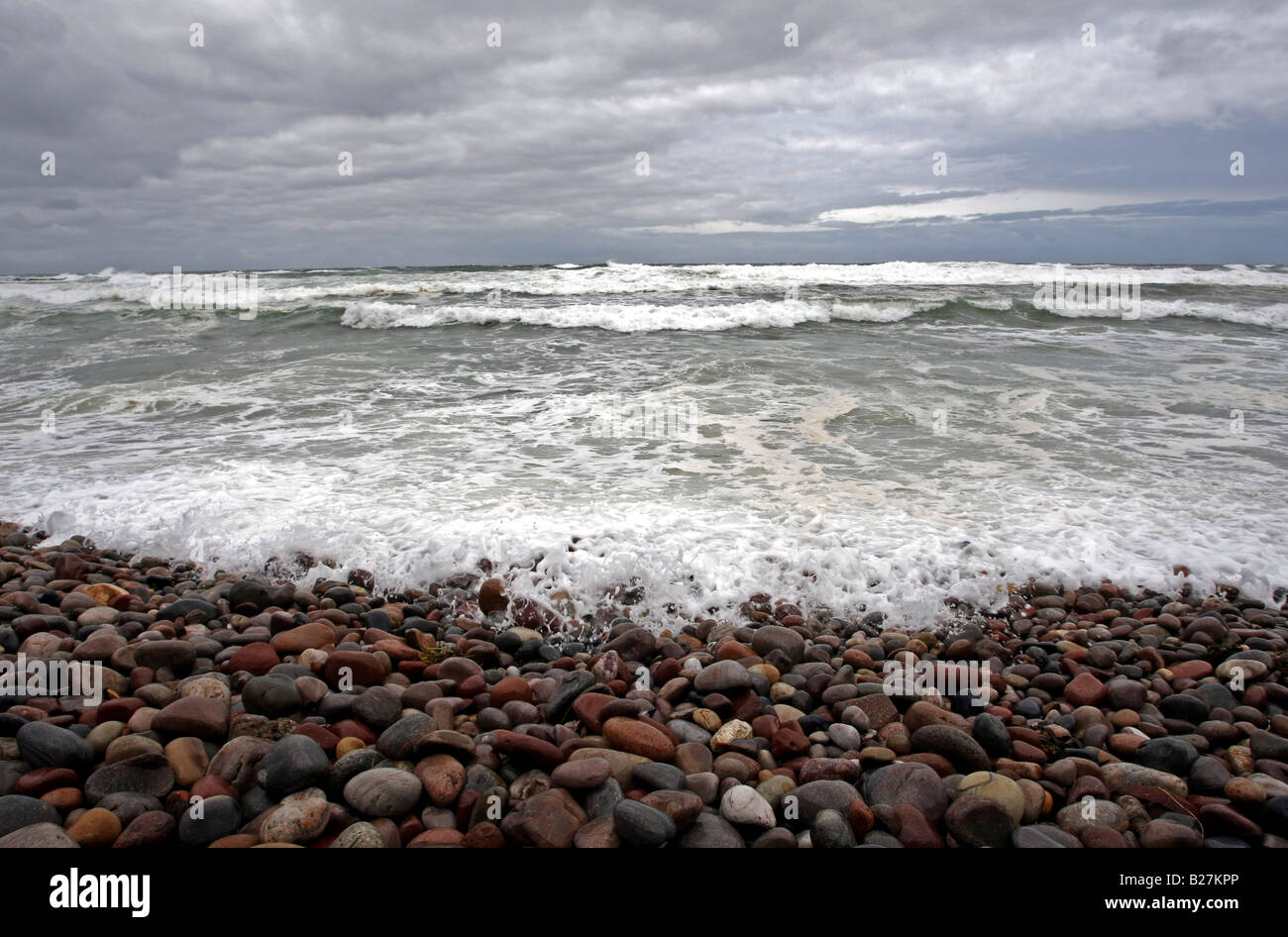 Shingle beach with pebbles and stones, stormy waves and grey sky Stock Photo Alamy